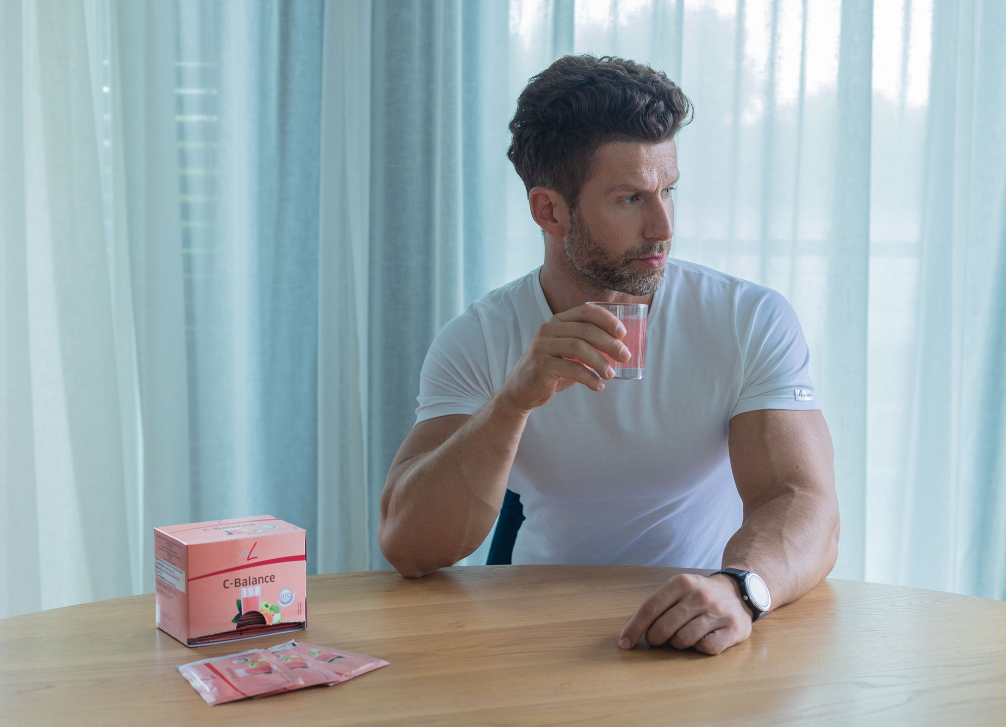 FitLine C-Balance met vitamine C in een glas, sachets en verpakking op tafel